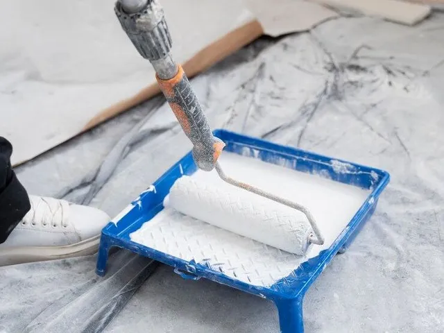high-angle-contractor-painting-house-wall